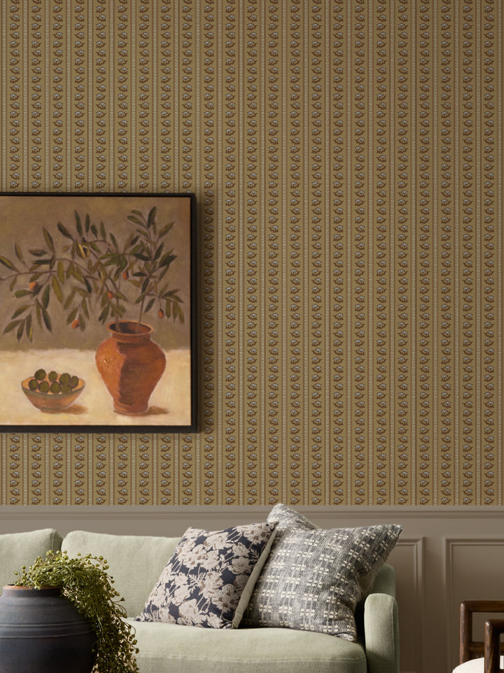 Aged Olive lotus stripe wallpaper above panelling with a sage sofa and a framed olive-branch still life