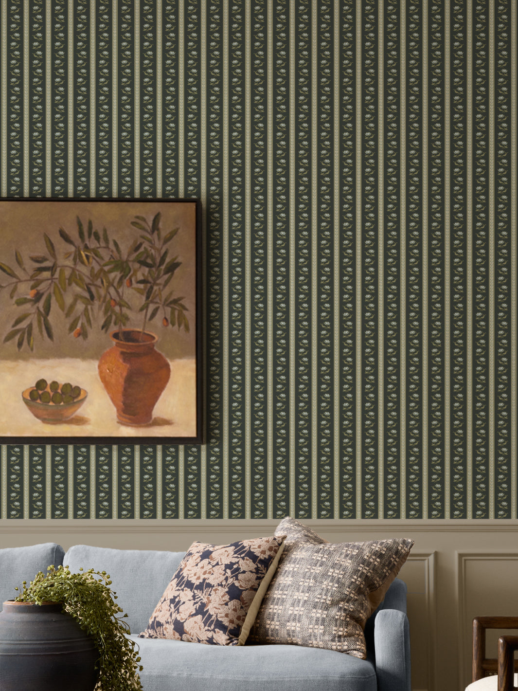 Dark green lotus stripe wallpaper with a pale blue sofa and a black urn with a trailing plant