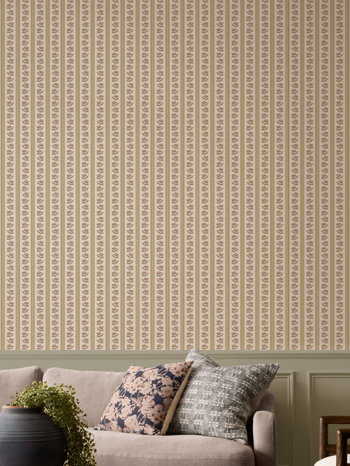 Parchment lotus stripe wallpaper with a greige sofa and a black urn holding a trailing plant