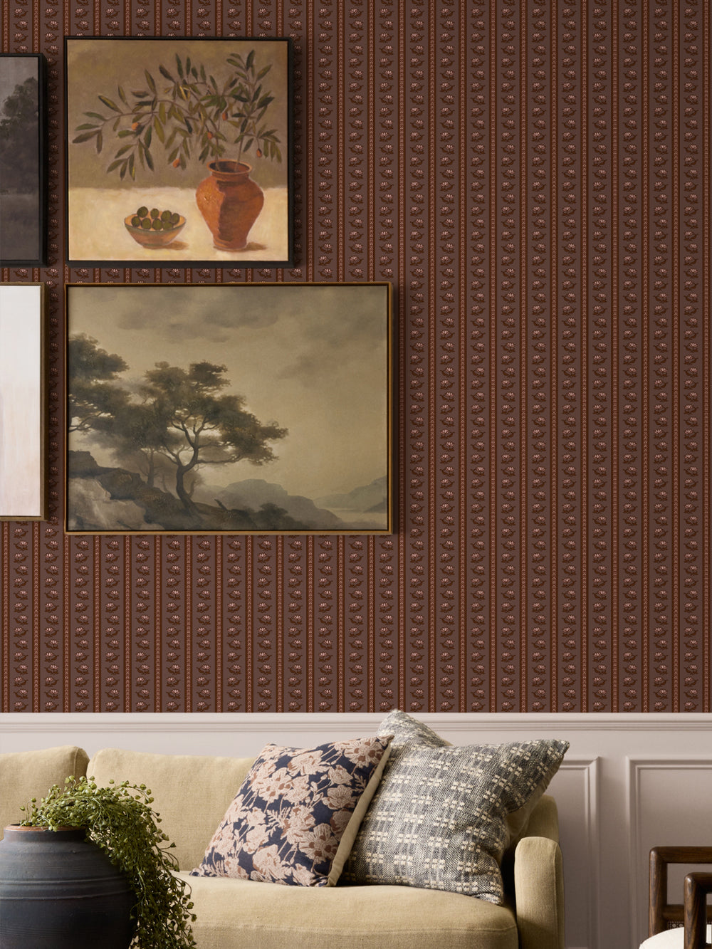 Mauve-brown lotus stripe wallpaper on a gallery wall with framed art and an oatmeal sofa