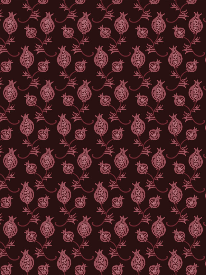 Close crop of muted dusty mauve-rose pomegranate motifs on very dark brown-black