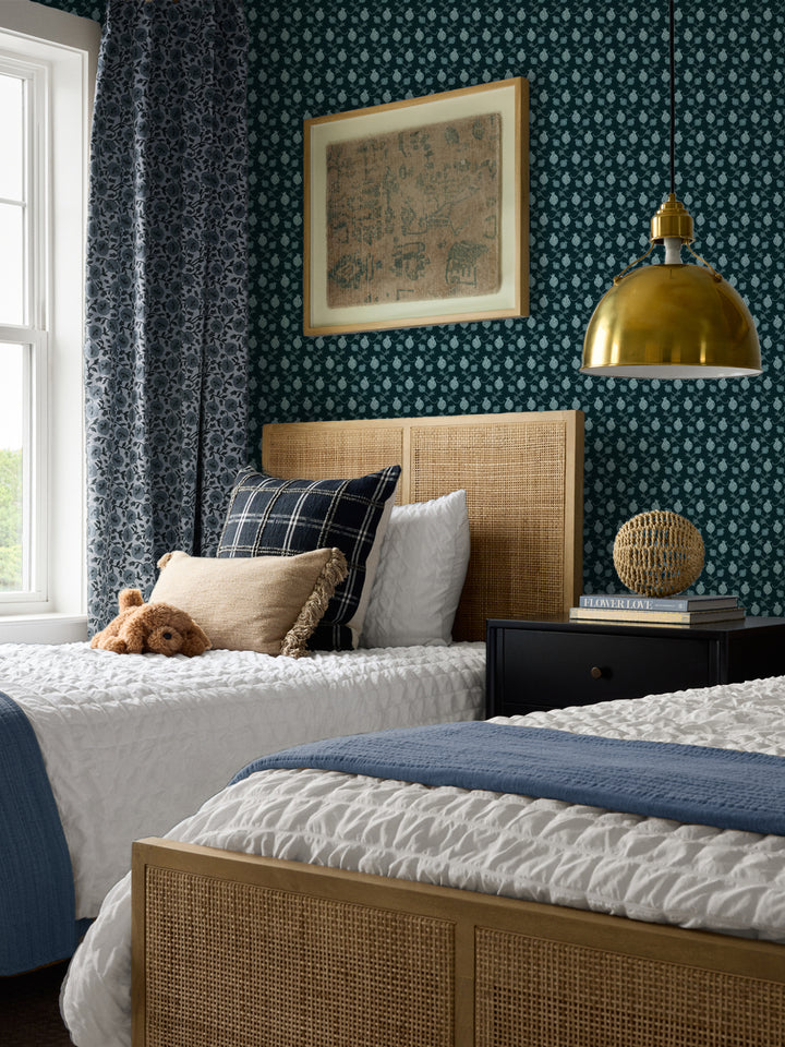 Cane beds with a plaid cushion and blue throw, black nightstand and brass pendant lamp