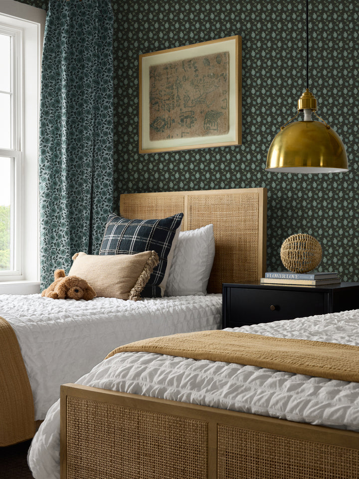 Cane beds with white bedding, a mustard throw, black nightstand and brass pendant lamp