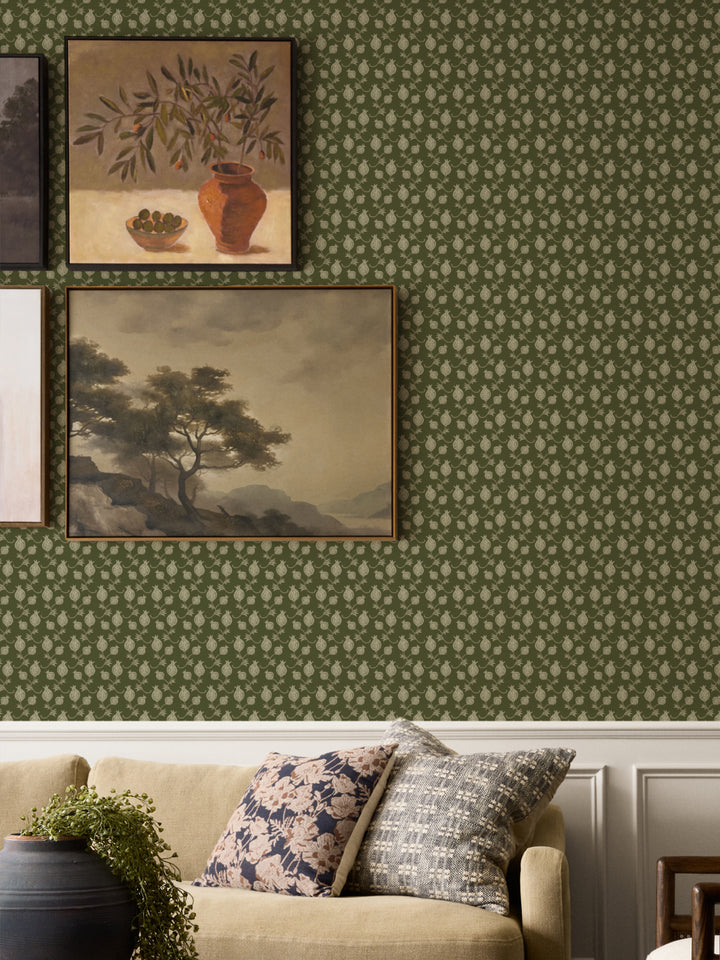 Framed still life and landscape above a tan sofa with floral cushions and a black planter