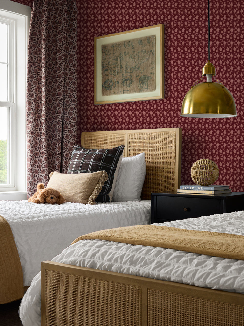Cane beds with a plaid cushion and mustard throw, black nightstand and brass pendant lamp