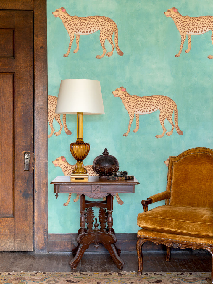 Cheetah print wallpaper with multiple standing tan cheetahs and dark spots on aqua blue