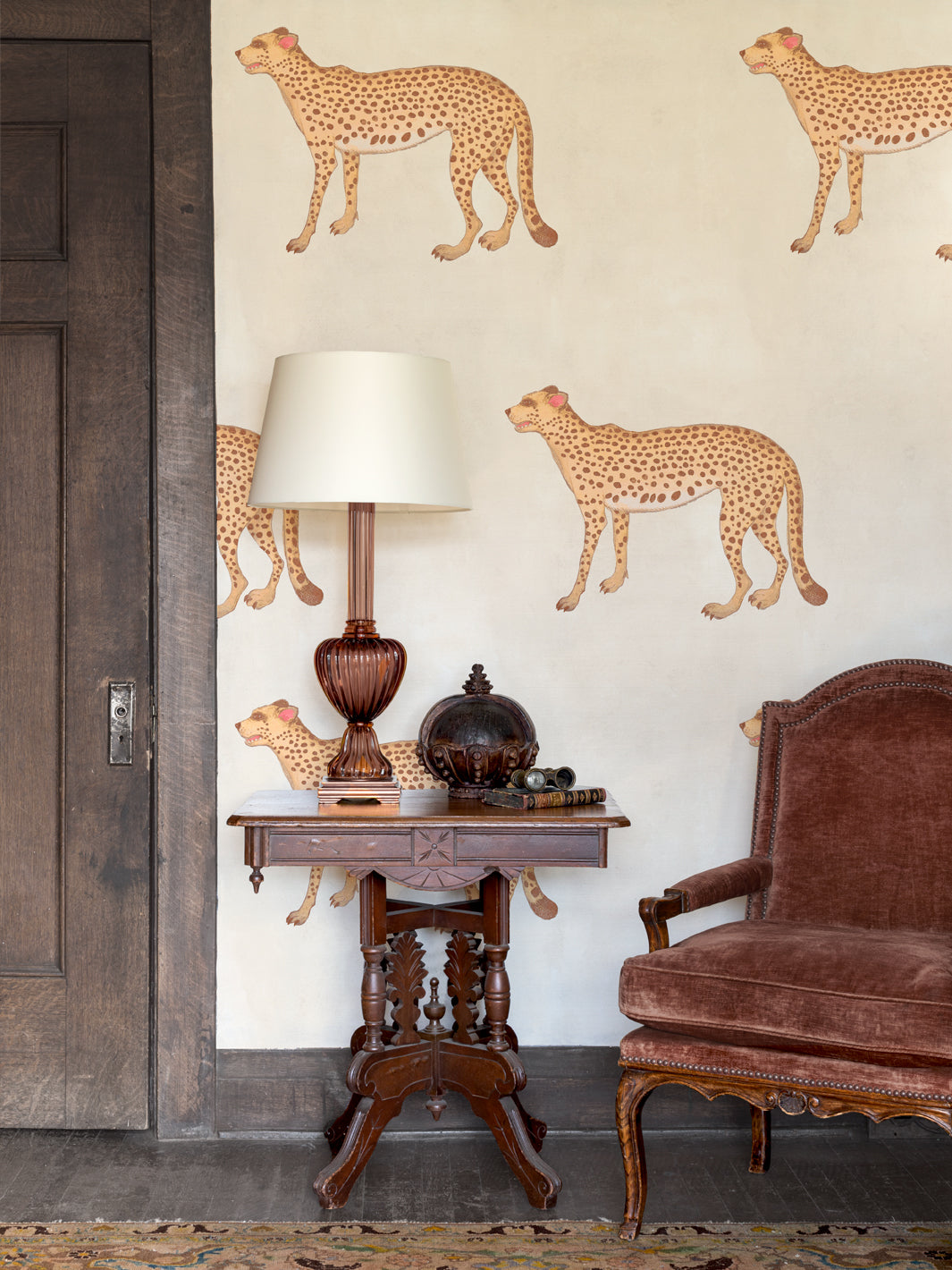 Ivory wall wallpaper with multiple tan cheetah motifs scattered across the surface