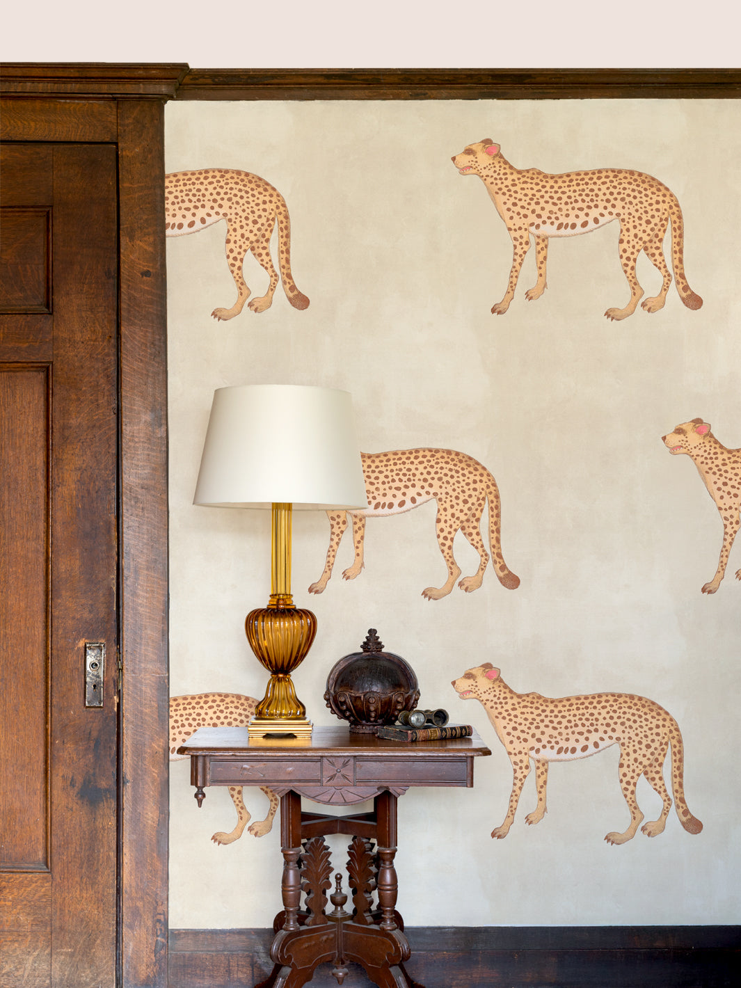 Cheetah wallpaper on wall with scattered spotted tan felines on parchment beige