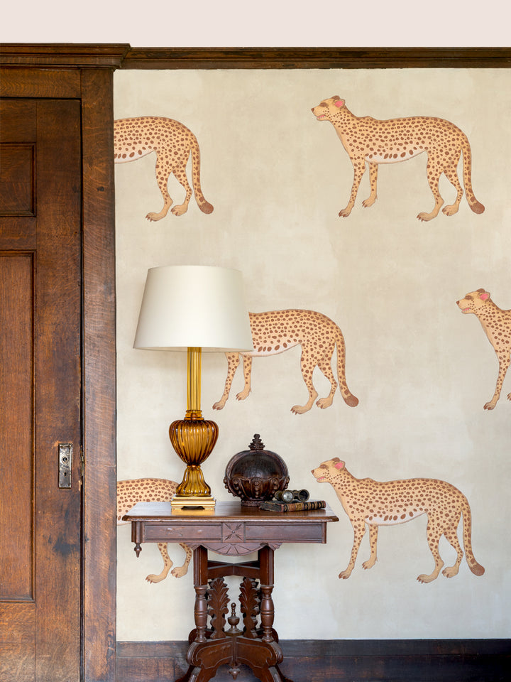 Cheetah wallpaper on wall with scattered spotted tan felines on parchment beige