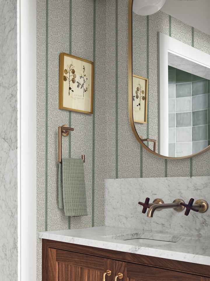 Powder room in sage vine wallpaper with walnut vanity, marble counter, brass faucet and gold mirror