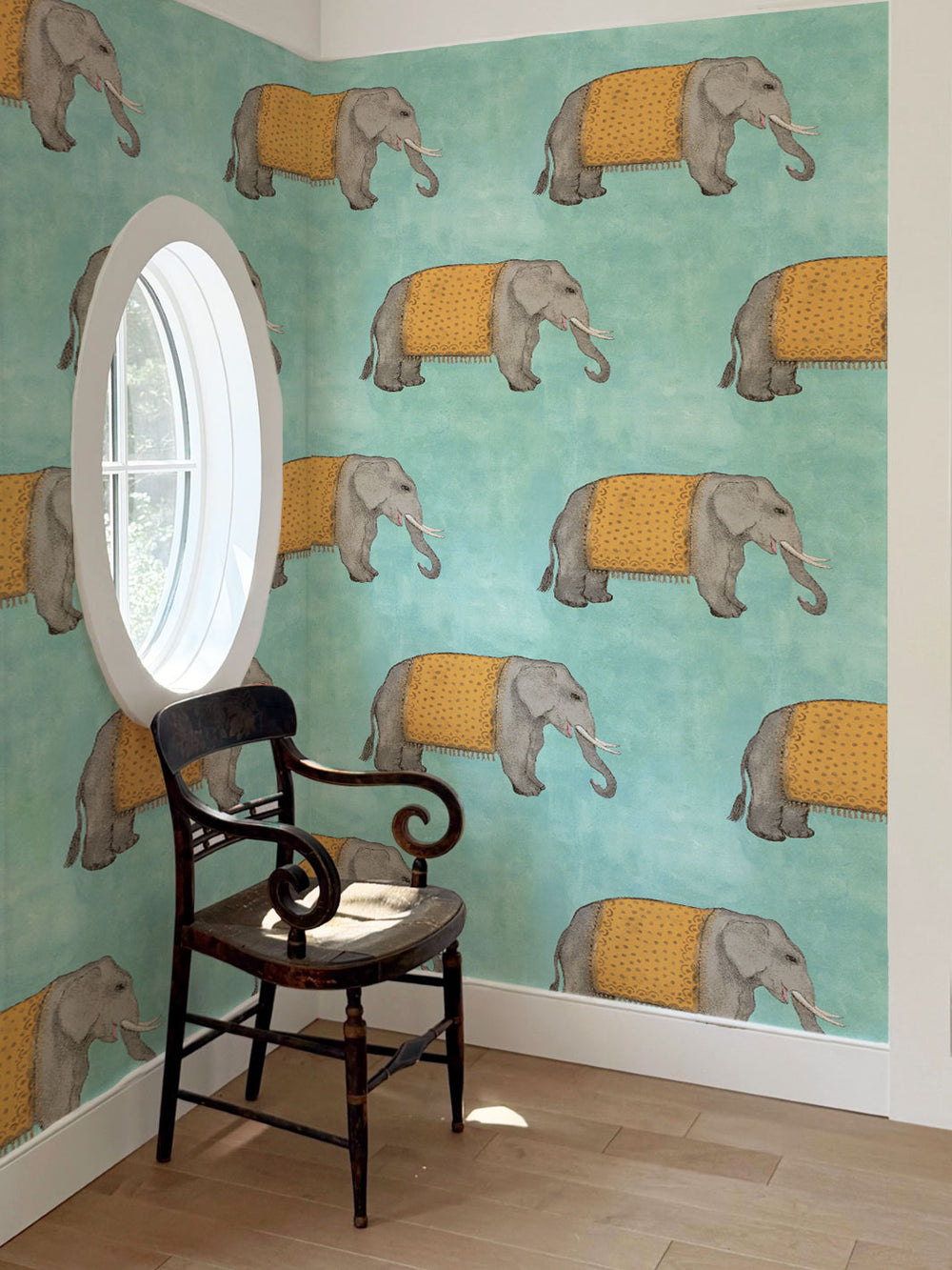 Elephant wallpaper mural with gray elephants and yellow patterned cloth on aqua blue wall
