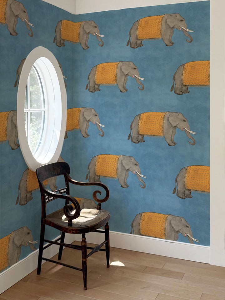 Elephant wallpaper with gray elephants wearing orange blankets across a repeating wall pattern