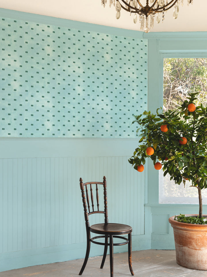 Four-leaf clover wallpaper on wall in light blue with small green clover repeat