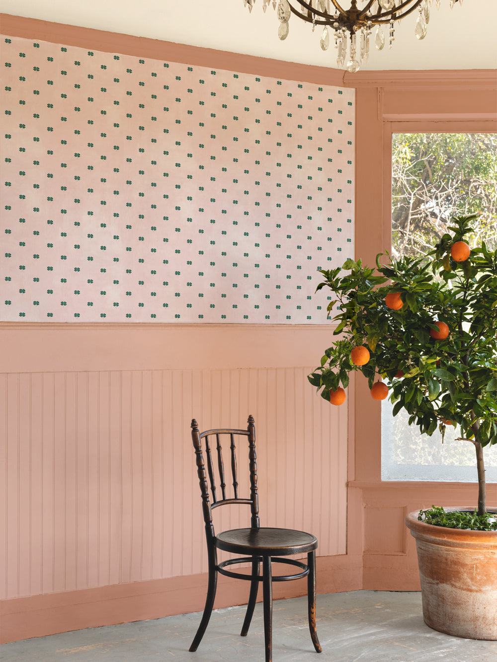 Blush four-leaf clover wallpaper with small green clover motifs on wall