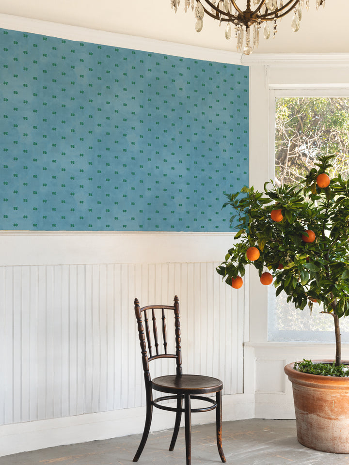 Four-leaf clover wallpaper panel with green motifs on cadet blue wall, room view