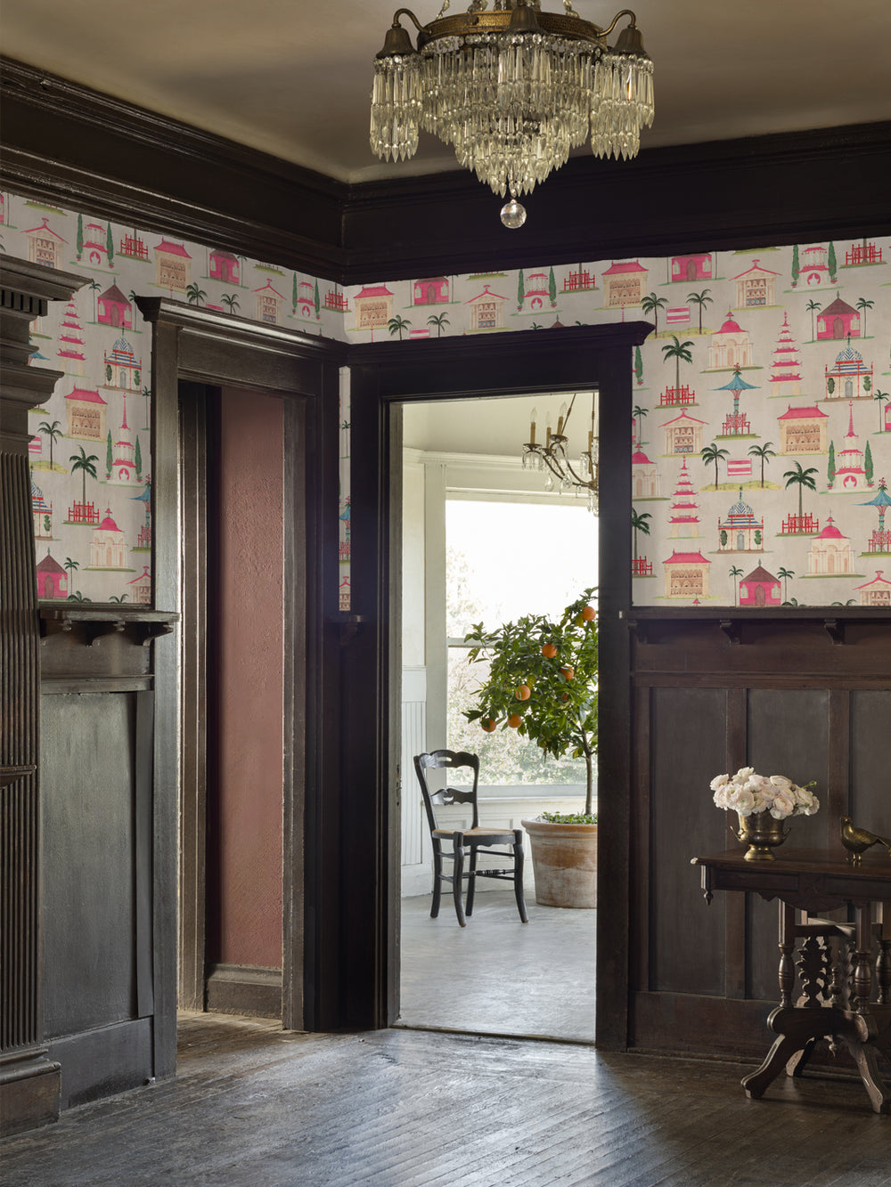 Decorative wallpaper with repeating pink pagodas and palms across room walls