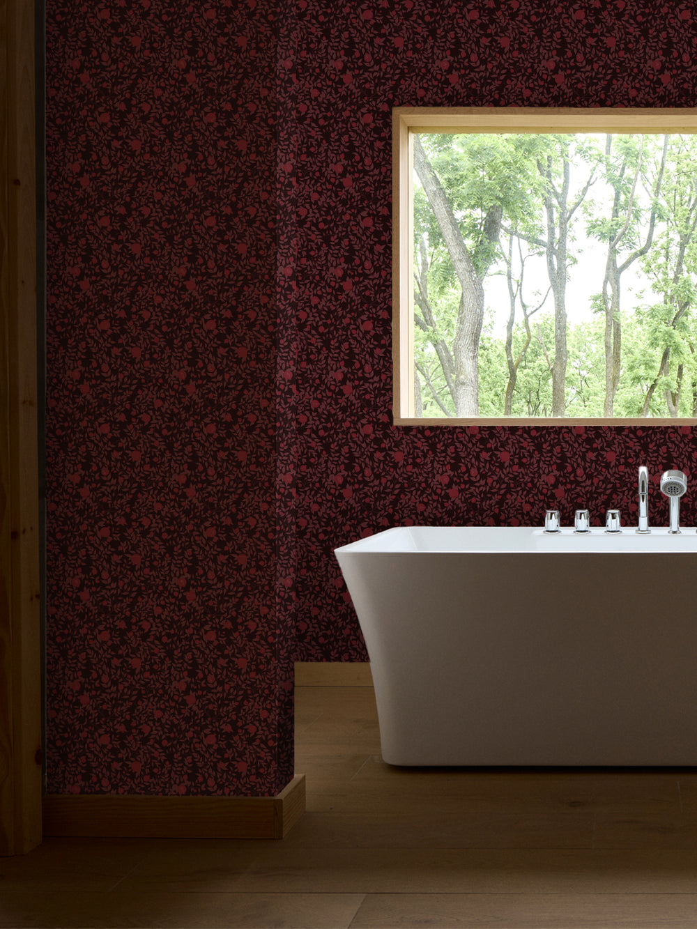 White freestanding tub with chrome faucet by a wood-framed window, walls in dark red pomegranate paper