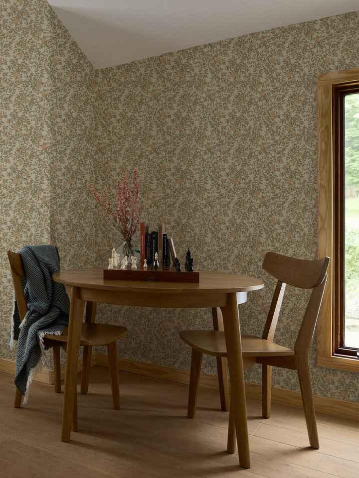 Round oak table and two chairs with a chess set and books against cream pomegranate wallpaper