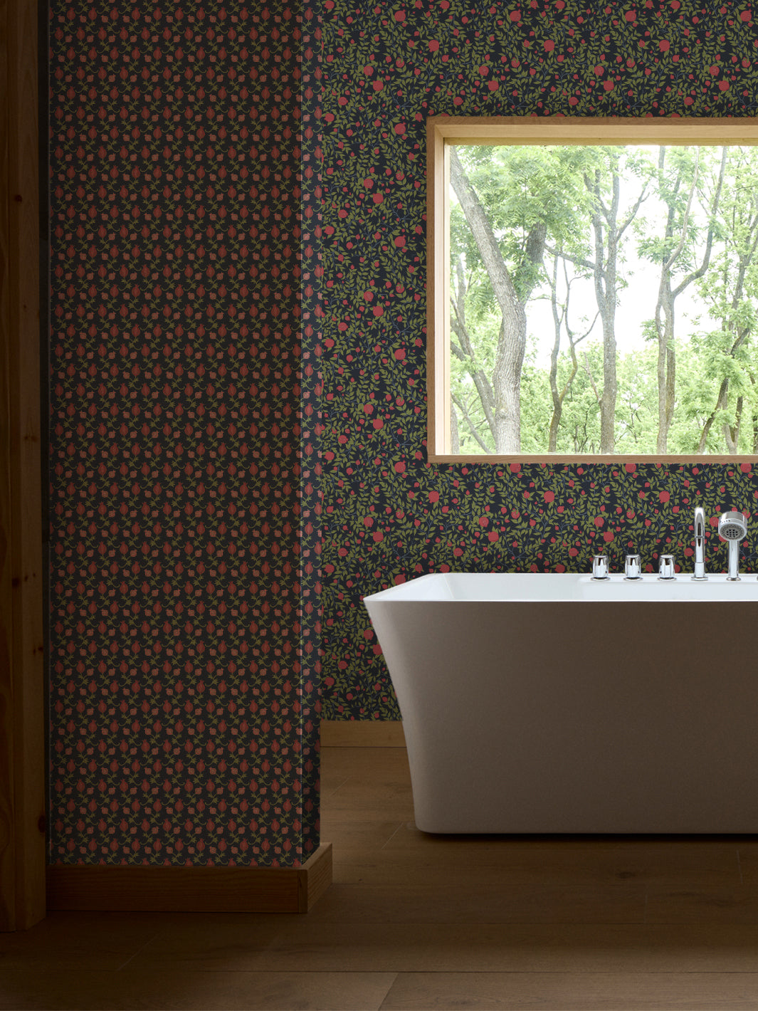 White freestanding tub and chrome faucet by a window, navy paper with green leaves and pink fruit