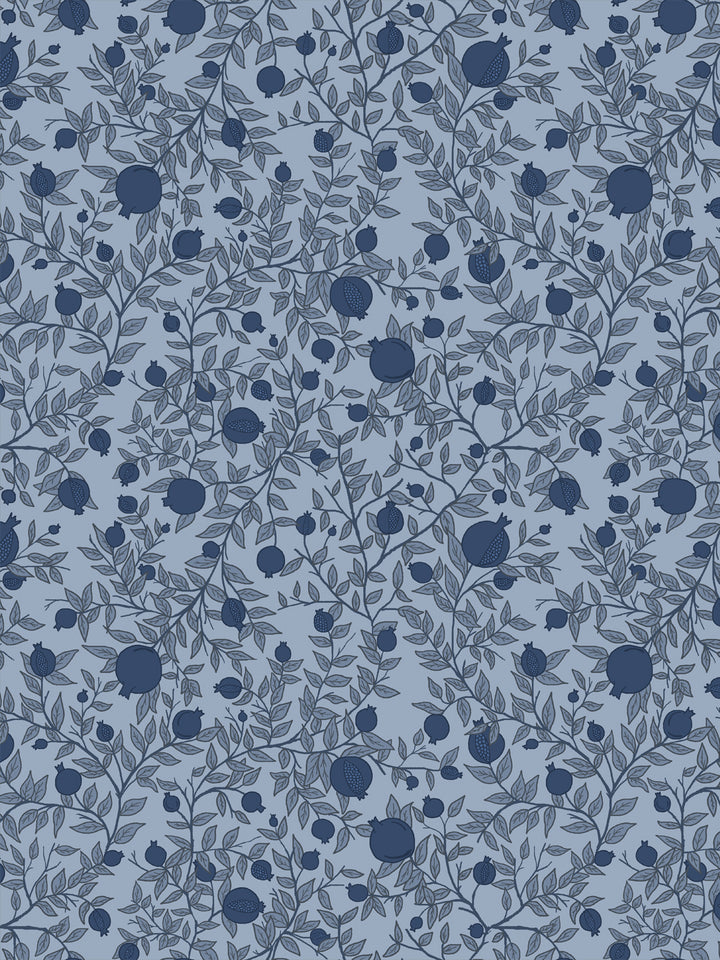 Tonal pomegranate branch wallpaper with navy fruit and grey-blue leaves on a dusty slate blue ground