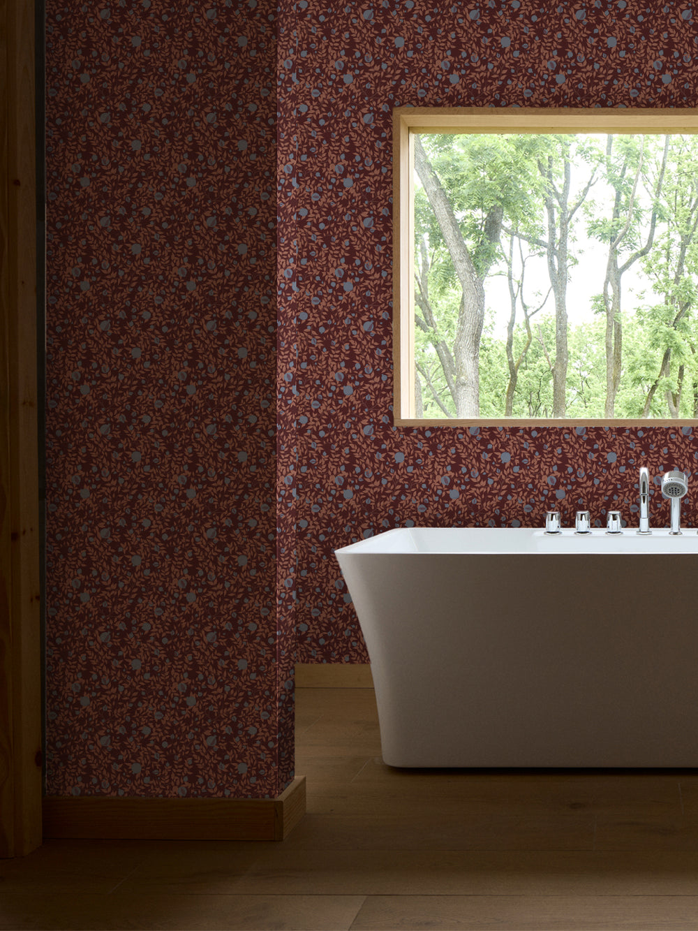 White freestanding tub and chrome faucet by a window, walls in plum wallpaper with blue fruit