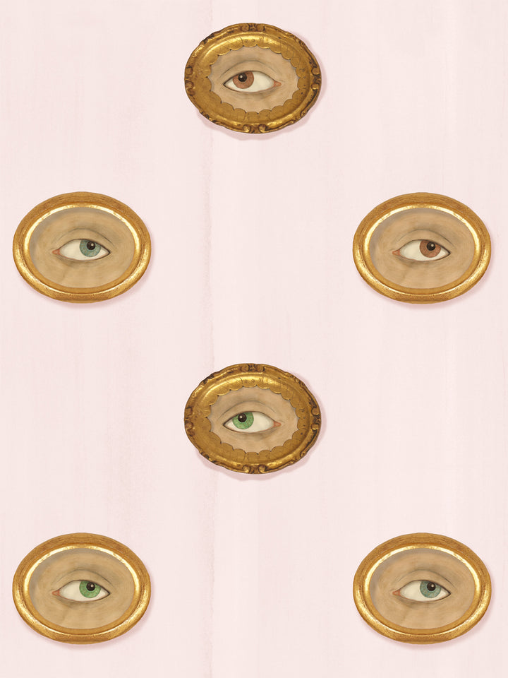 Pale blush pink wallpaper with gilt oval frames holding painted eyes in brown, green and blue-gray