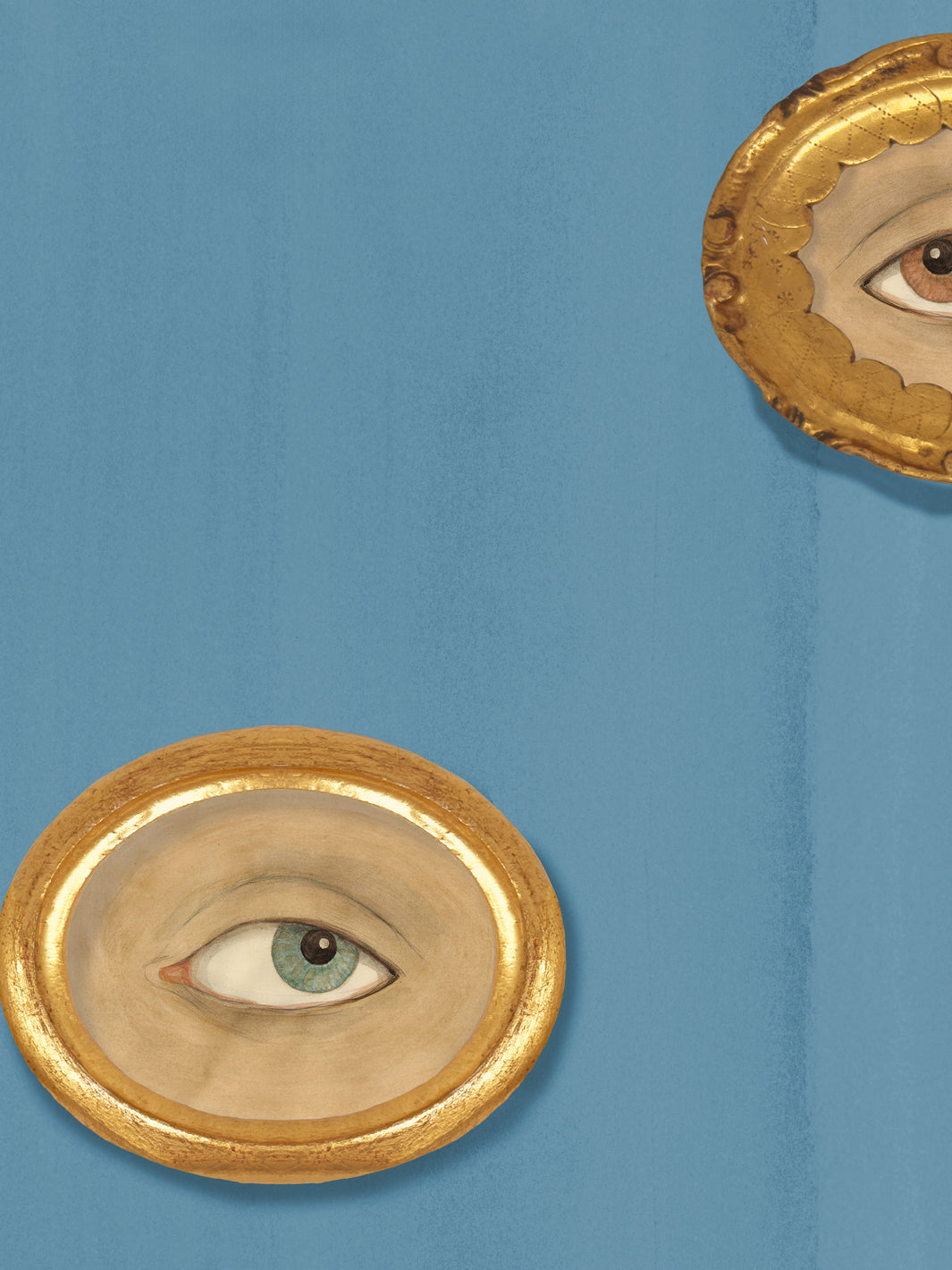 Close-up of cadet blue wallpaper showing a gold oval frame around a painted sea-green eye