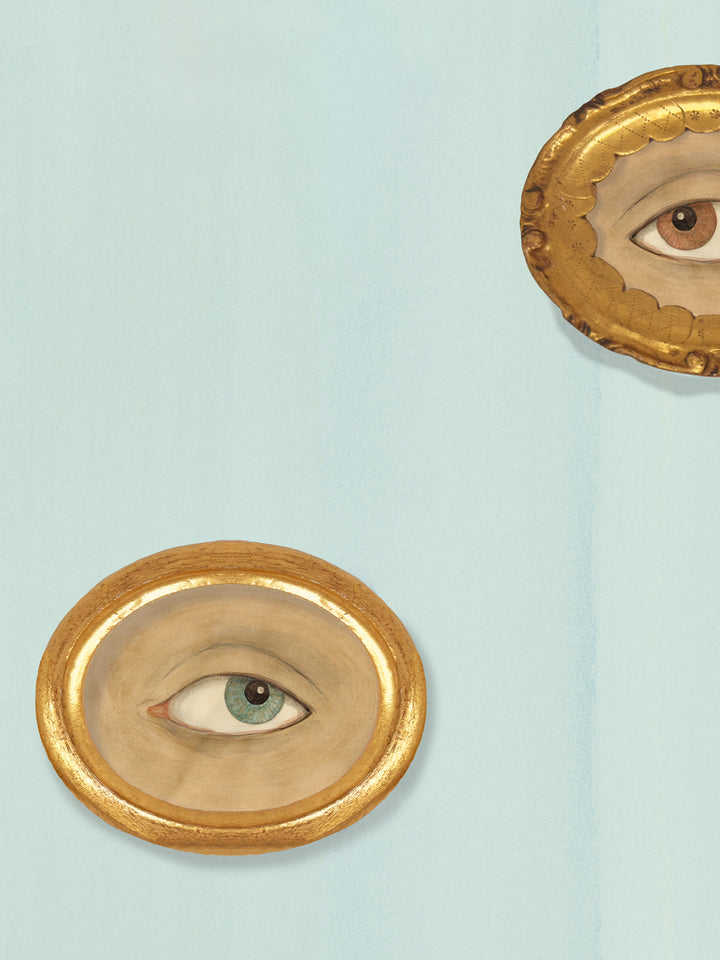 Close-up of blue wallpaper with gold oval eye frames