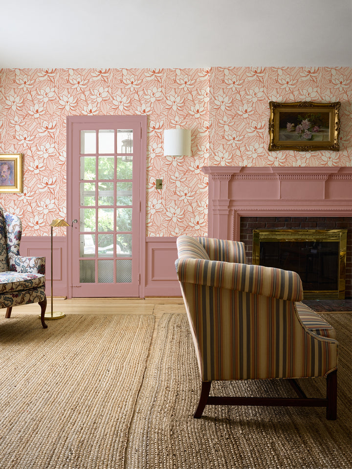 Apricot Ember Magnolias wallpaper in a living room with striped settee, pink fireplace and jute rug
