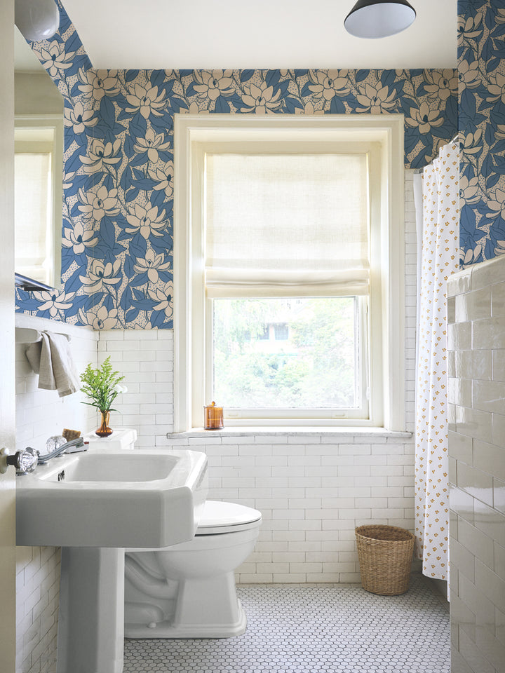 Linen Cornflower Magnolias wallpaper in a tiled bathroom with pedestal sink and roman shade