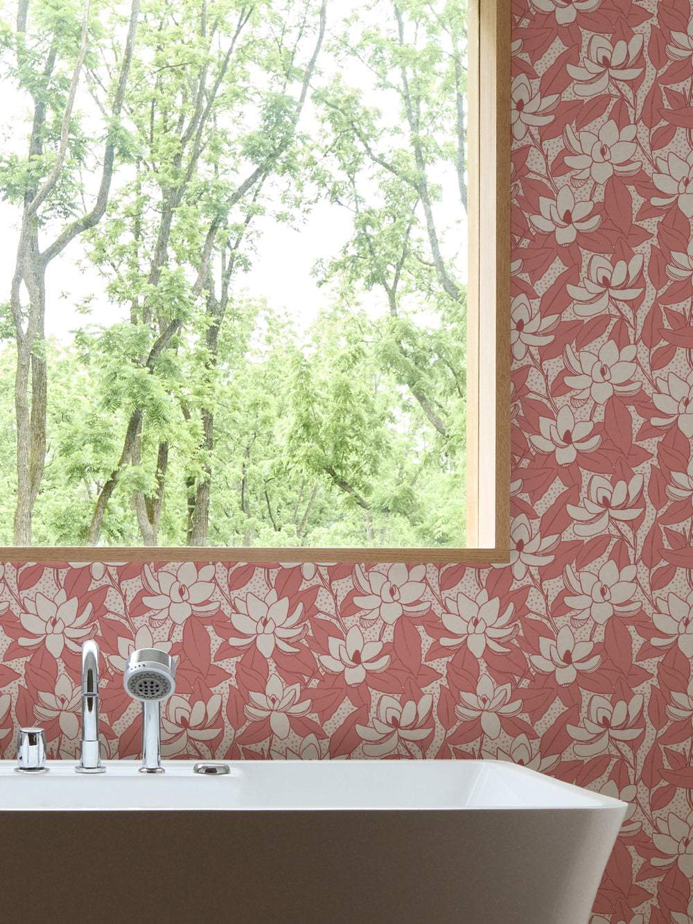 Pomelo Pink Magnolias wallpaper in a bathroom with white freestanding tub and oak-framed window