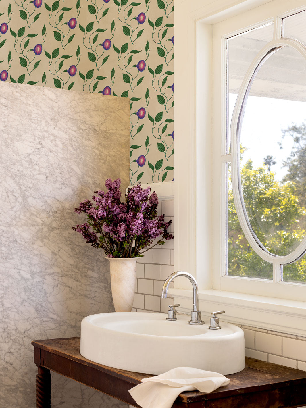 Floral wallpaper on wall with purple morning glory blooms and green leaves on parchment