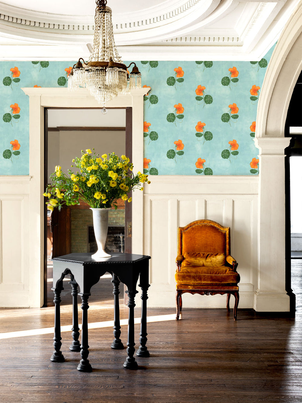 Floral wallpaper in a room with orange nasturtiums and green leaves on light blue wall