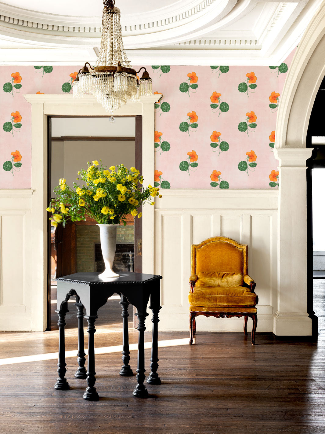 Blush floral wallpaper with orange flowers and green leaves on interior wall