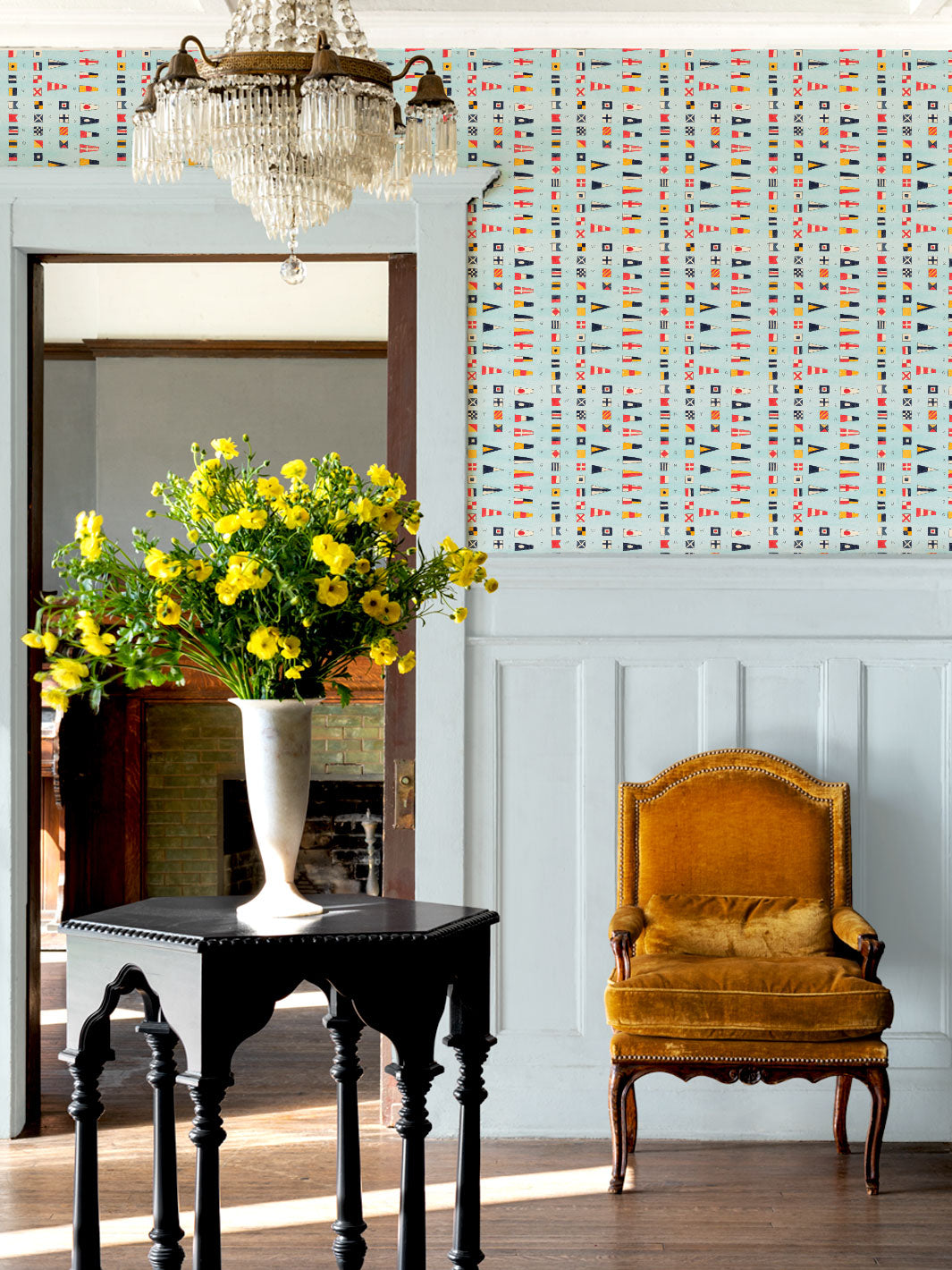 Nautical flags wallpaper covering a wall behind a yellow upholstered chair