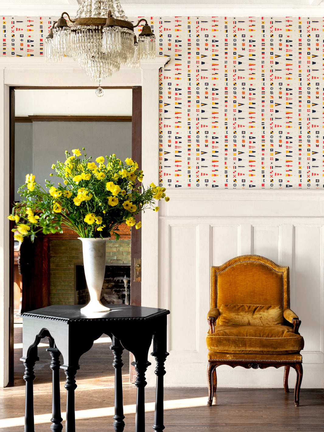 Nautical flag wallpaper covering a wall, with chair and table in foreground