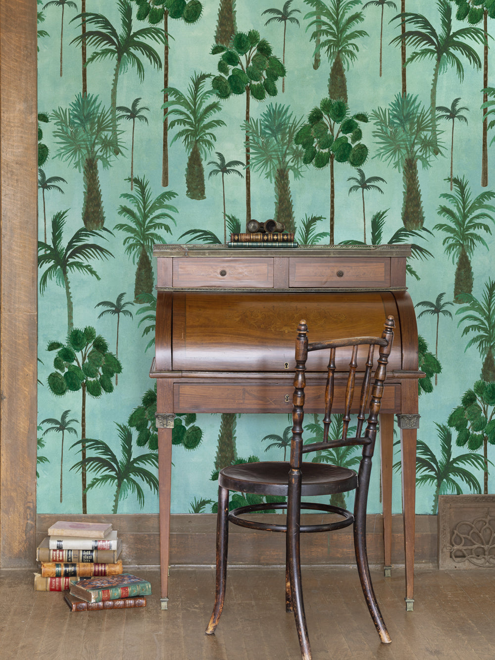 Aqua tropical palm wallpaper with green trees and foliage pattern behind furniture