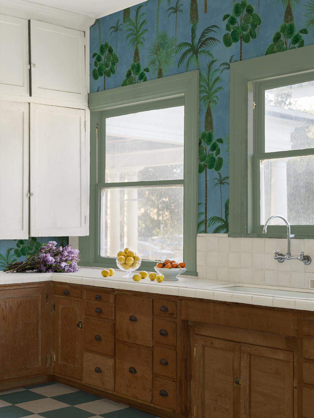 Tropical palm forest wallpaper covering a wall above a kitchen counter.