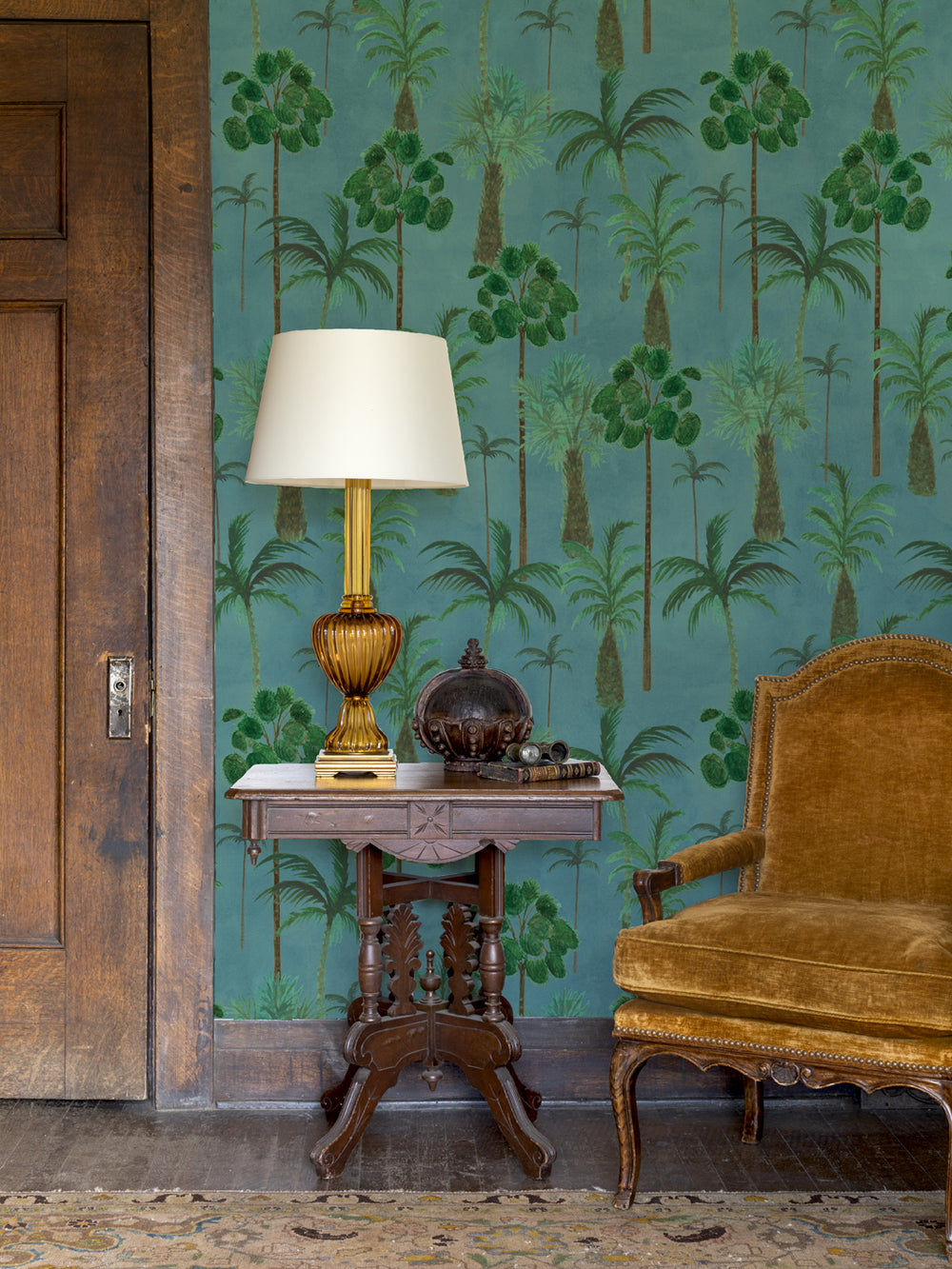 Tropical palm wallpaper on wall with teal background and green tree silhouettes