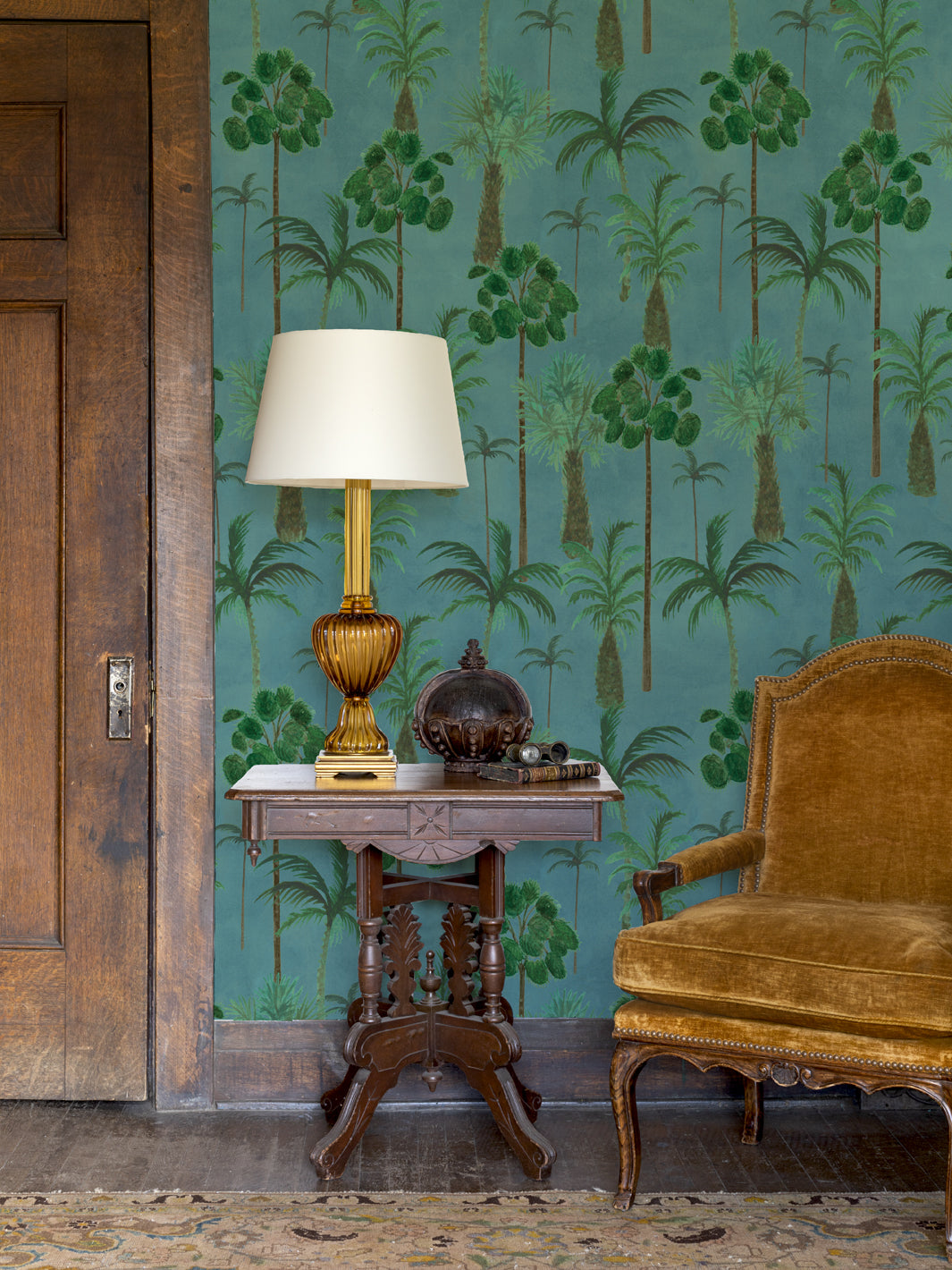 Tropical palm wallpaper on wall with teal background and green tree silhouettes