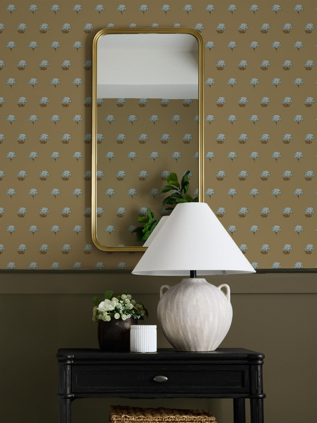 Entry wall in blue and camel peony wallpaper with a gold mirror, ceramic lamp and black console
