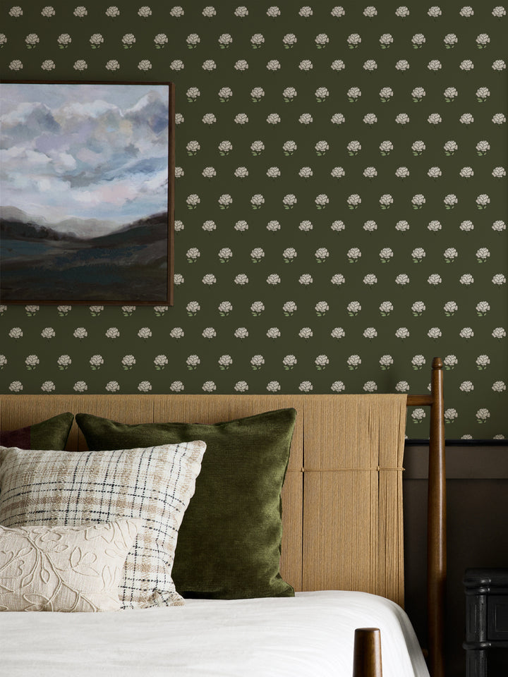 Bedroom wall in cream on olive peony wallpaper with a rattan headboard and cloud landscape art