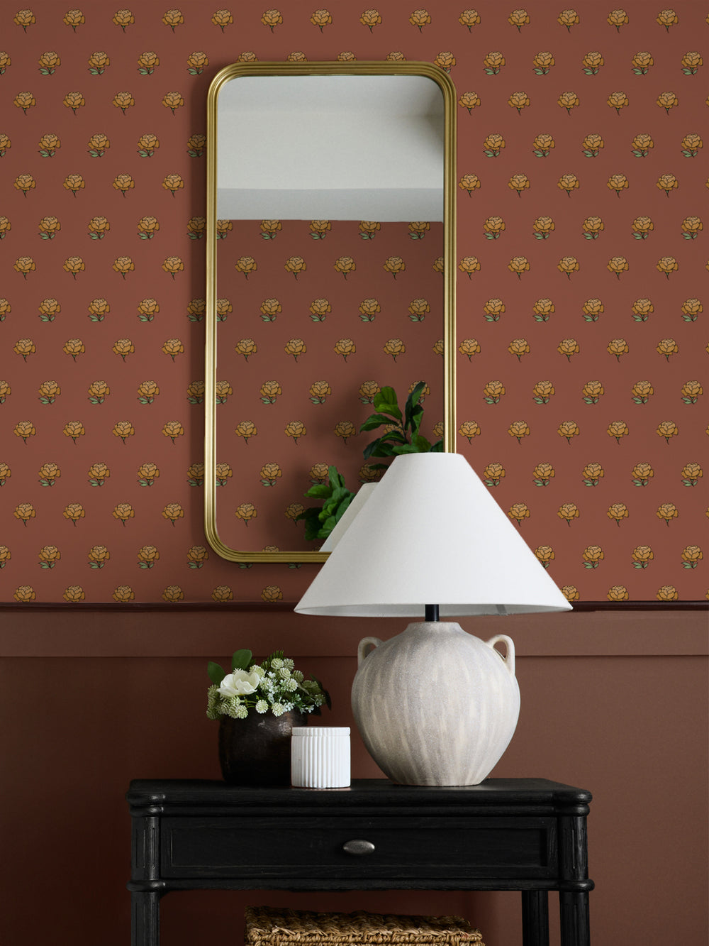 Entry wall in terracotta and gold peony wallpaper with a gold mirror and black console table