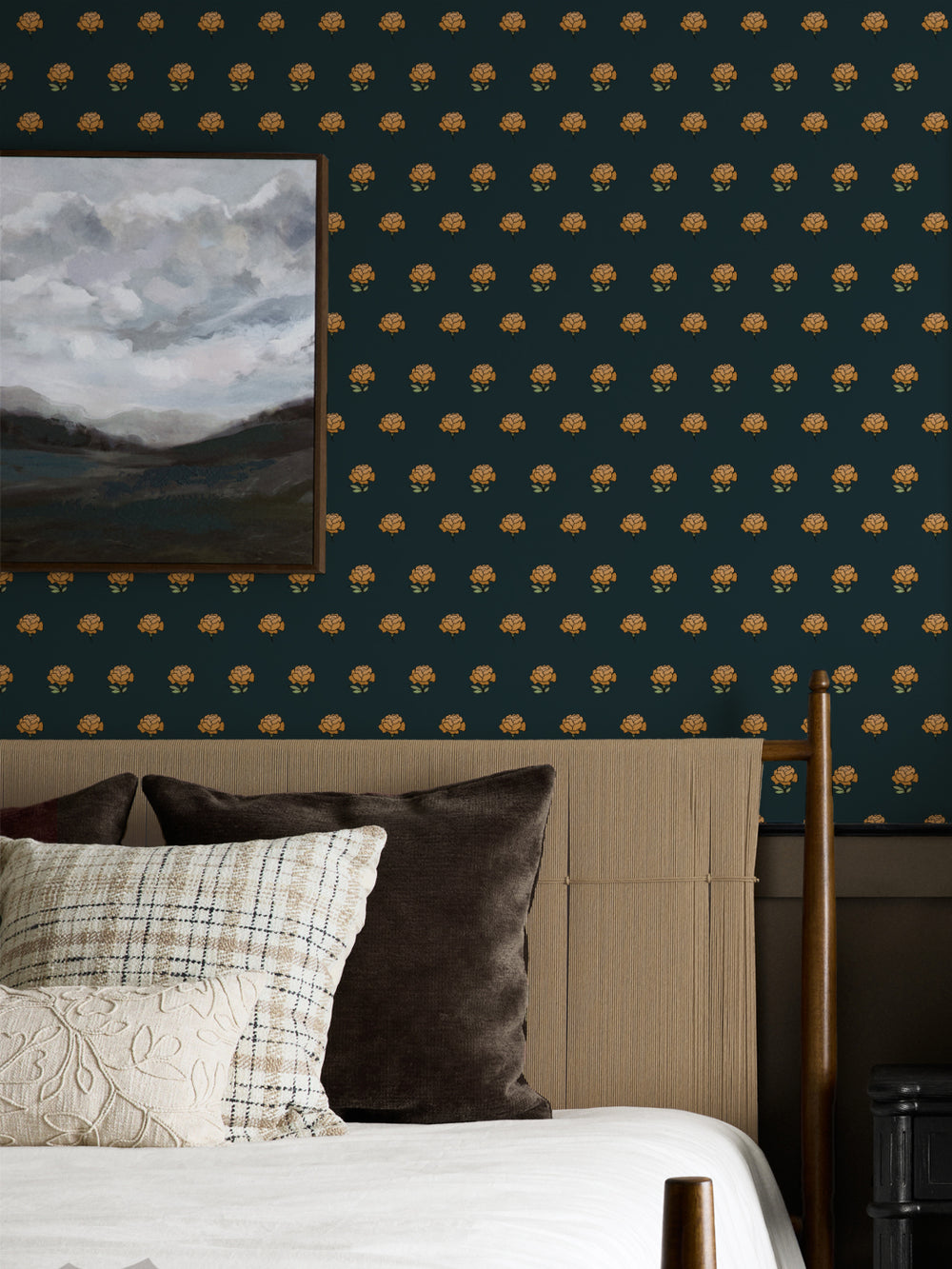 Bedroom wall in gold on black peony wallpaper with a cane headboard and cloud landscape art