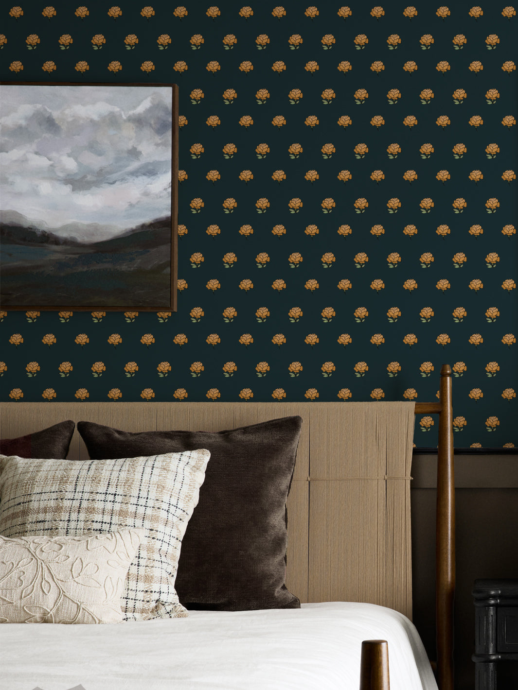 Bedroom wall in gold on black peony wallpaper with a cane headboard and cloud landscape art