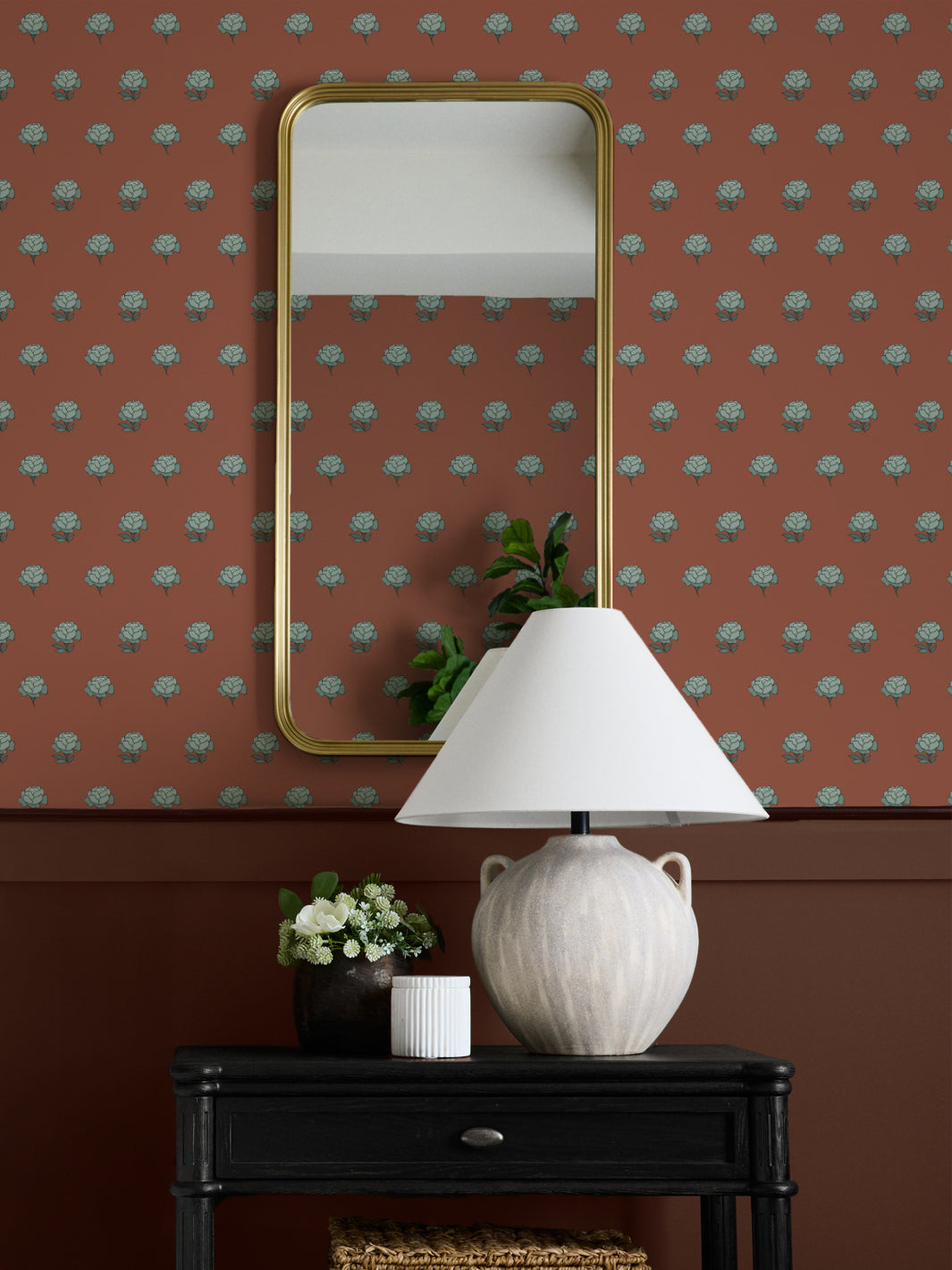 Entry wall in rust and seafoam peony wallpaper with a gold mirror and black console table