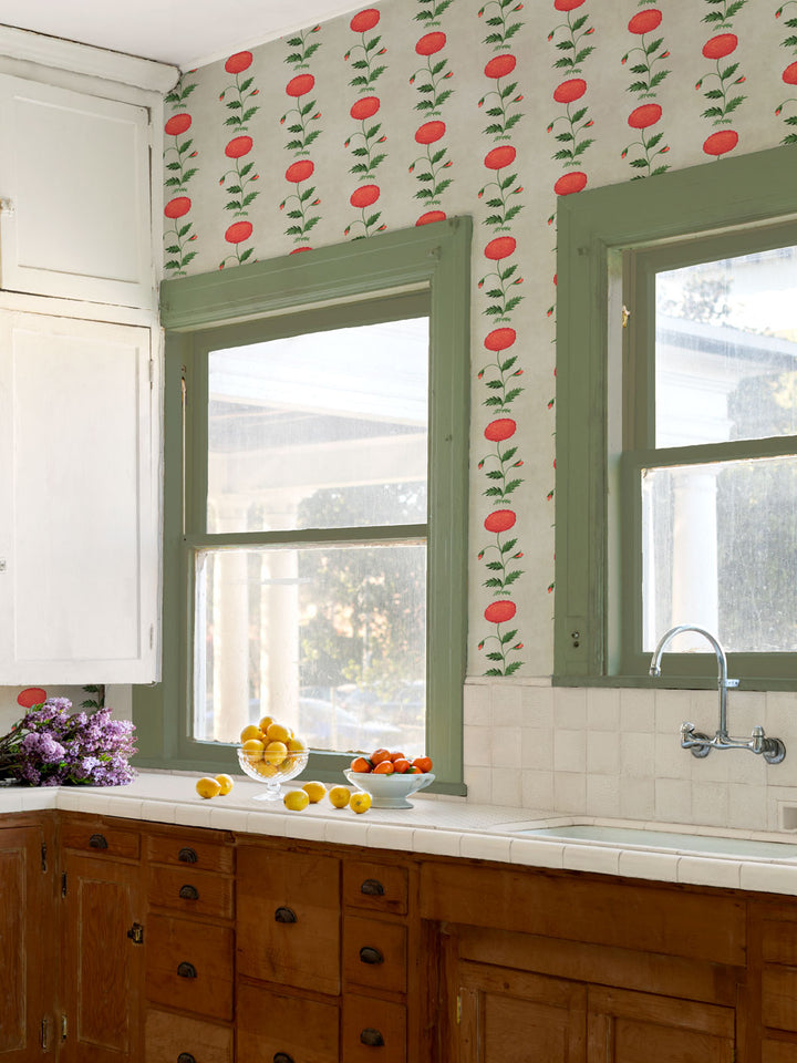 Floral wallpaper across kitchen wall: red persimmon blooms and green leaves near windows