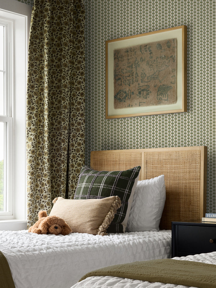 Green and cream Pomara Bloom wallpaper in a bedroom with a cane headboard and olive curtain