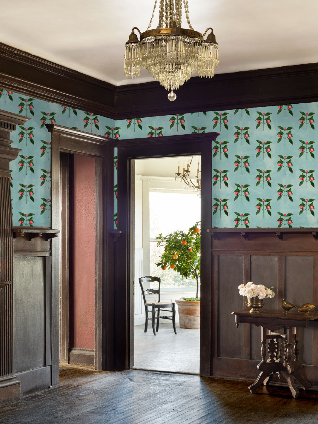 Floral raspberry wallpaper installed in a room, with repeating red blossoms and vines