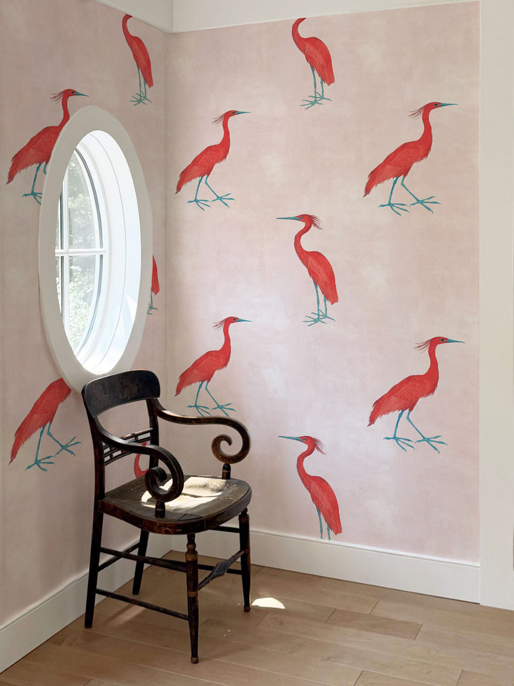Blush wallpaper with red egret bird pattern across a corner wall